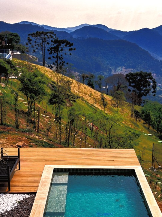 Deck de madeira com piscina e vista para a serra