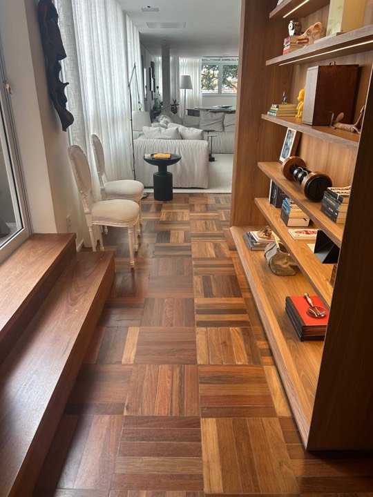 Piso de taco de madeira em sala com estante e degraus de madeira